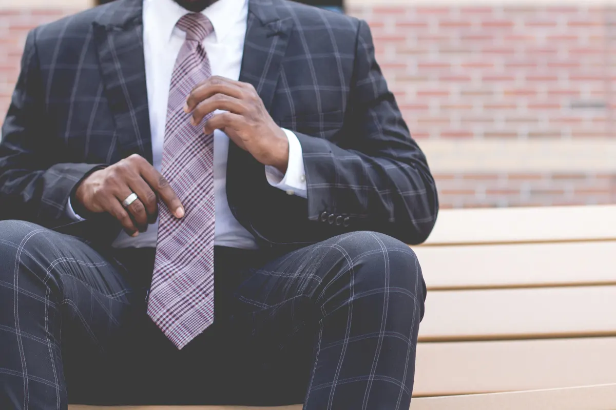 Man in a suit adjusting his tie